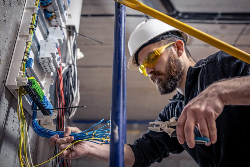 Electrician working inside an open residential electrical panel